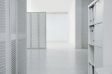 Image of Blurred view of empty office corridor with furniture