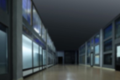 Image of Blurred view of empty office corridor with glass walls