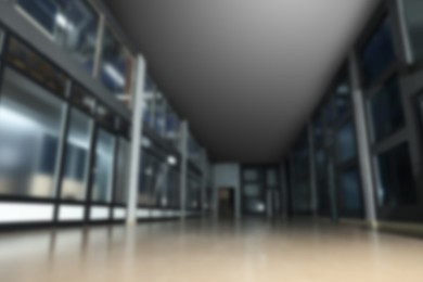 Image of Blurred view of empty office corridor with glass walls