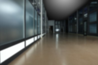 Image of Blurred view of empty office corridor with glass wall