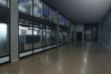 Image of Blurred view of empty office corridor with glass walls