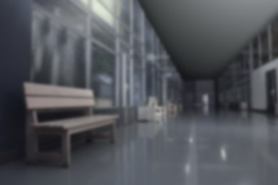 Image of Blurred view of empty office corridor with benches