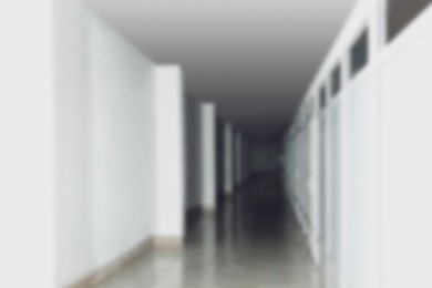 Image of Blurred view of empty office corridor with white wall