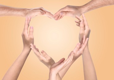 Image of People making heart shape with hands on dark beige background. Teamwork, unity, togetherness