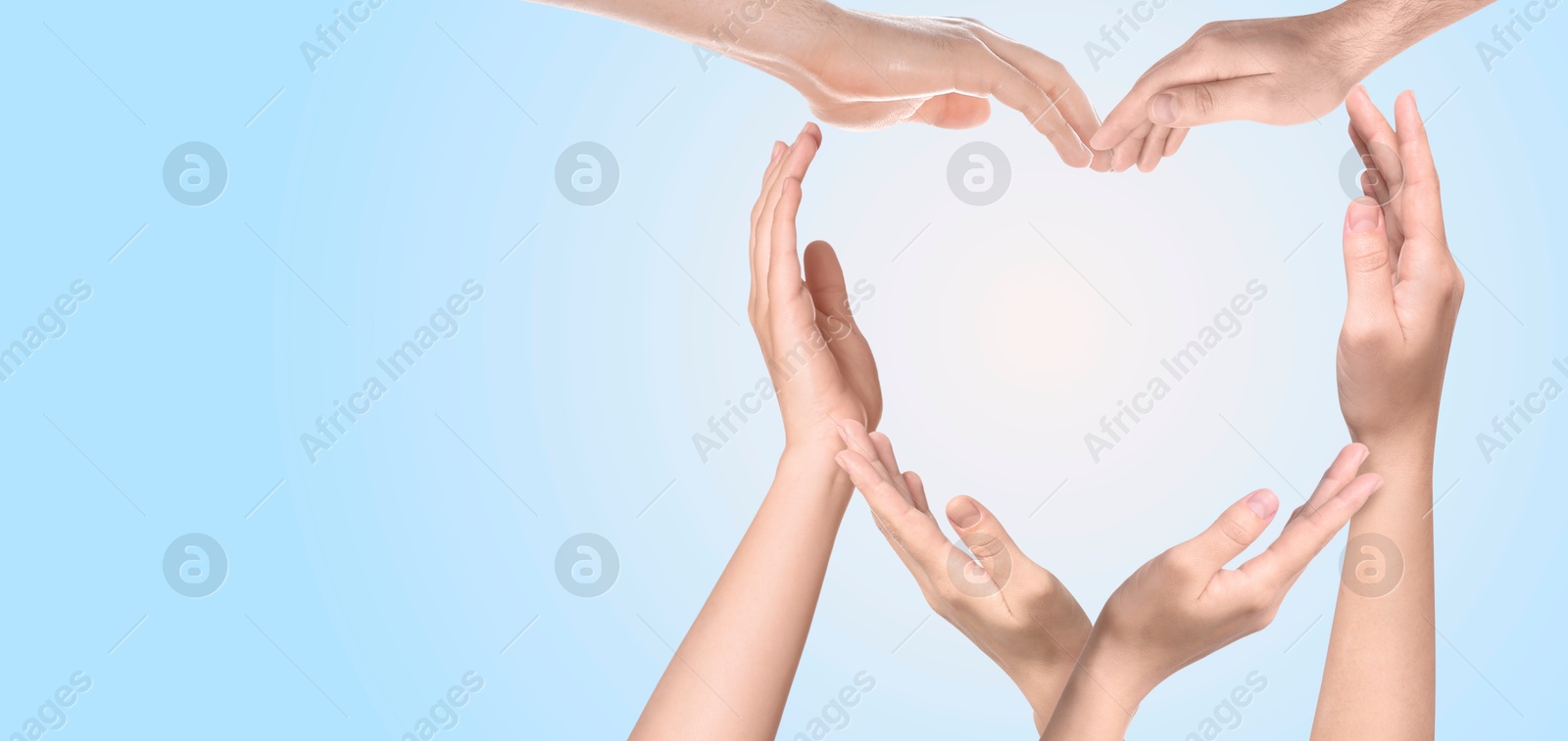 Image of Heart shape made with hands of different people on light blue background, banner design with space for text. Teamwork, unity, togetherness