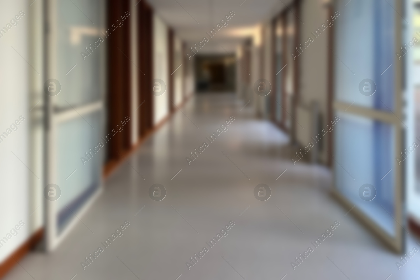 Image of Blurred view of empty hospital corridor with glass doors