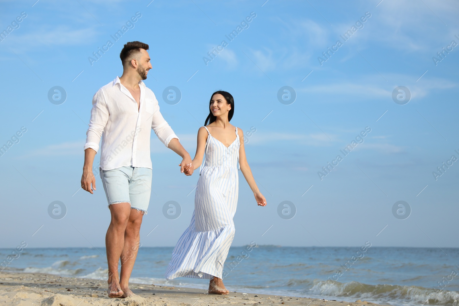 Photo of Happy young couple walking together on beach