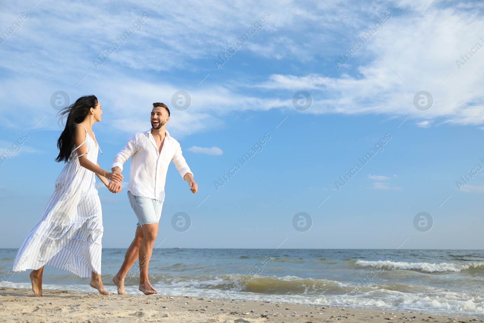 Photo of Happy young couple running together on beach