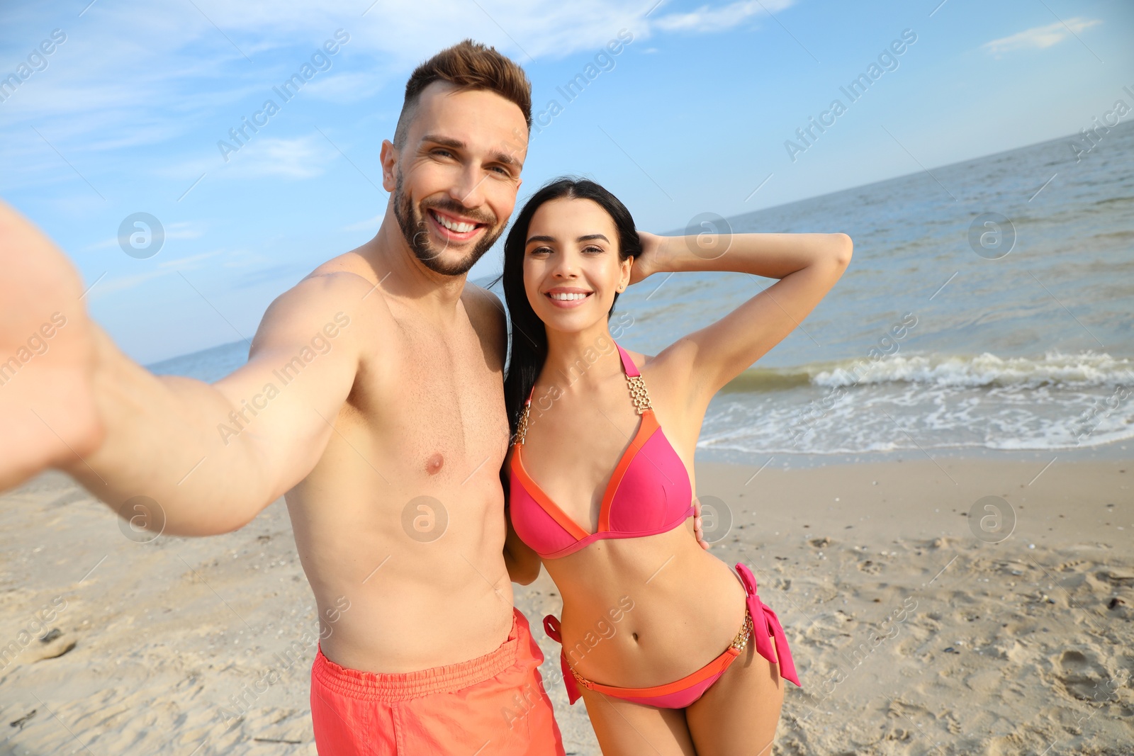 Photo of Happy young couple taking selfie on beach