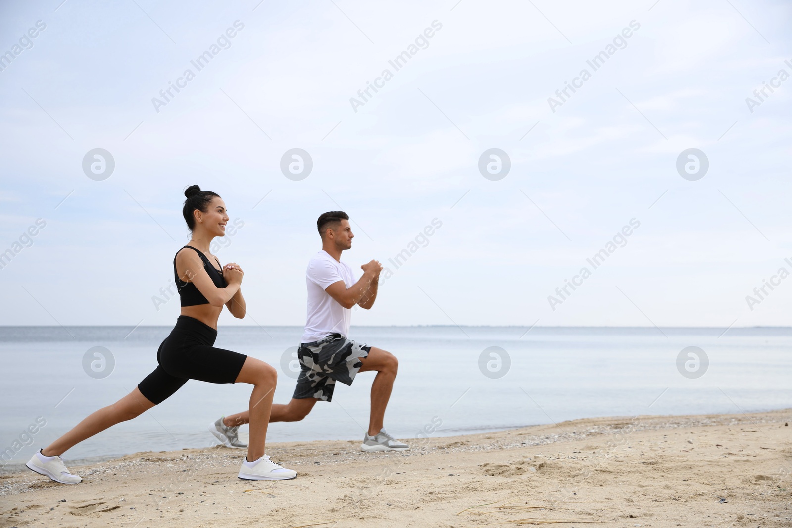 Photo of Couple doing exercise together on beach, space for text. Body training