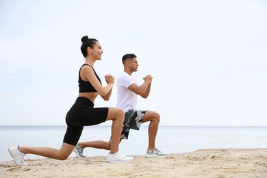 Photo of Couple doing exercise together on beach, space for text. Body training