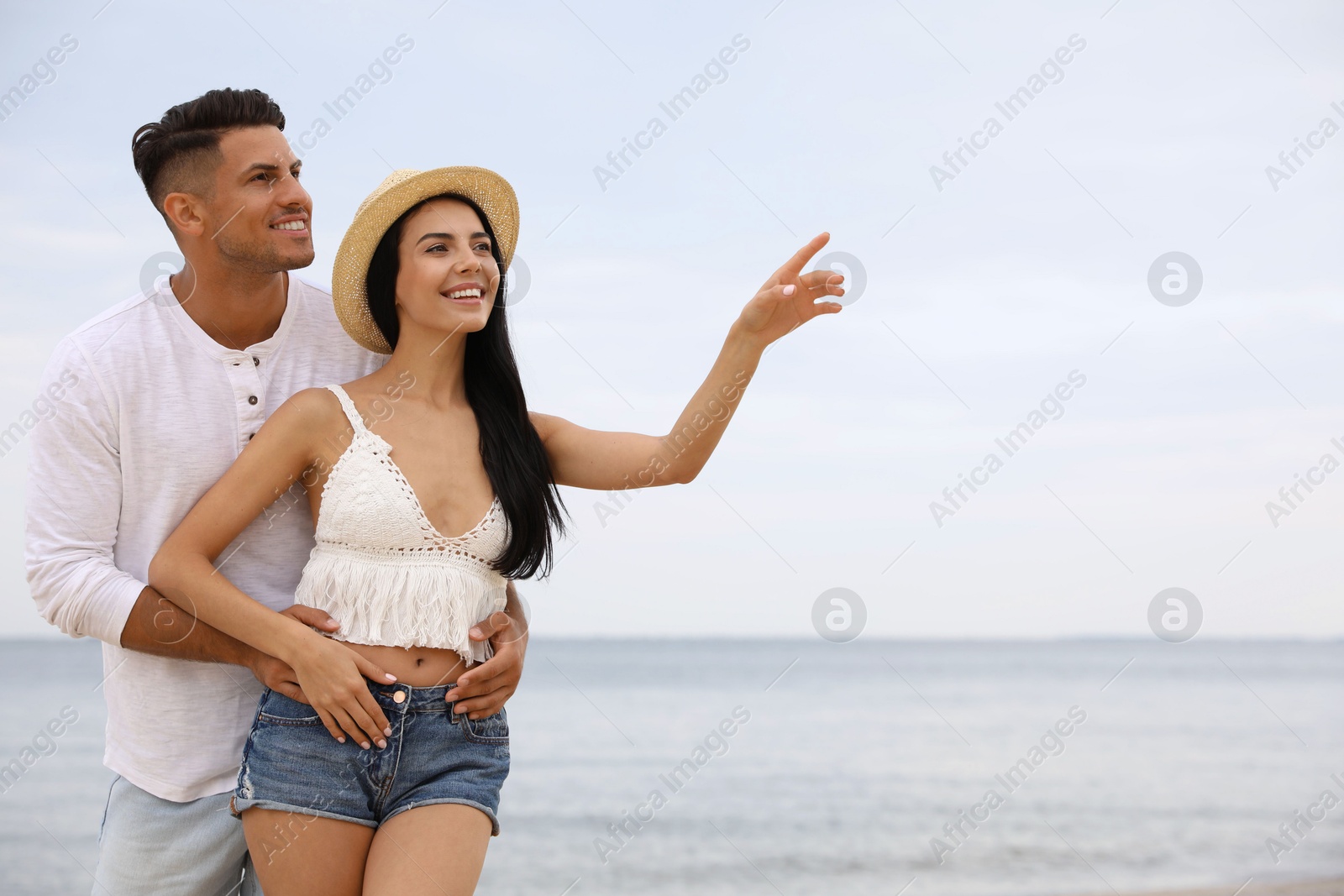 Photo of Lovely couple spending time together on beach. Space for text