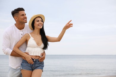 Photo of Lovely couple spending time together on beach. Space for text