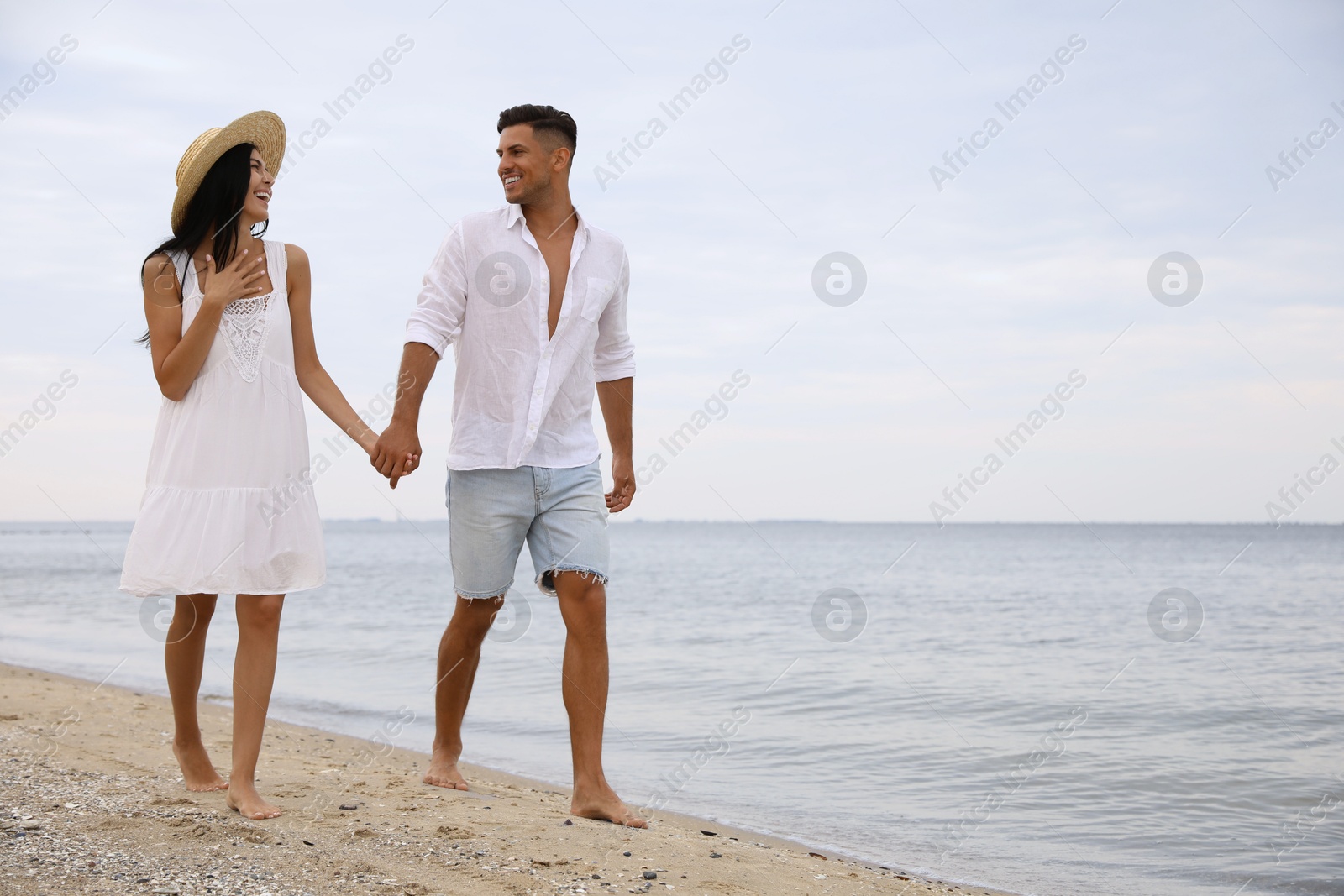 Photo of Lovely couple walking on beach. Space for text