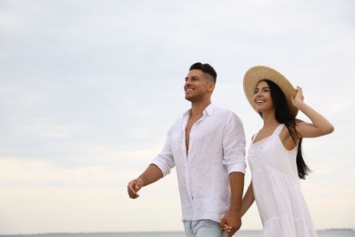 Photo of Lovely couple walking near sea. Space for text