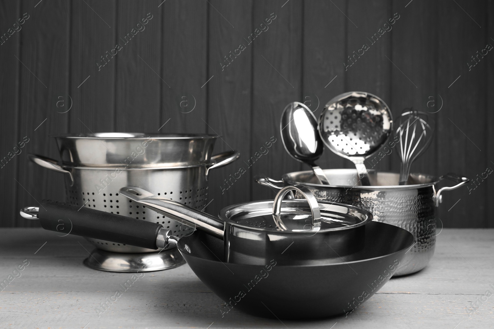 Photo of Dishware and cooking utensils on grey wooden table