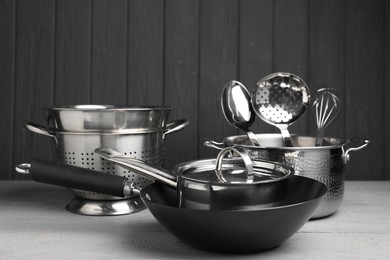 Photo of Dishware and cooking utensils on grey wooden table