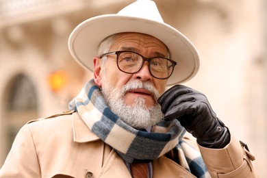 Photo of Portrait of elegant senior man in hat outdoors