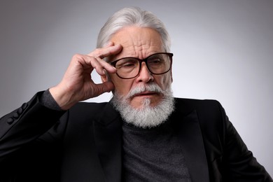 Photo of Thoughtful senior man on light grey background