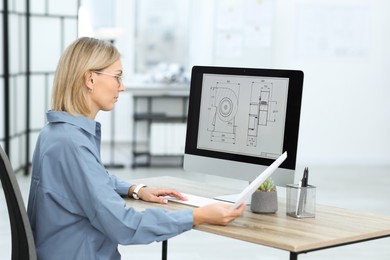 Photo of Technician making digital engineering drawing on computer at desk in office