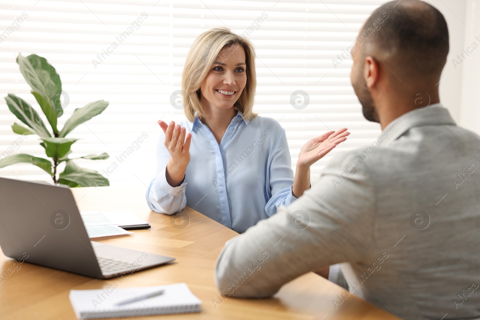 Photo of Coworkers working together at table in office