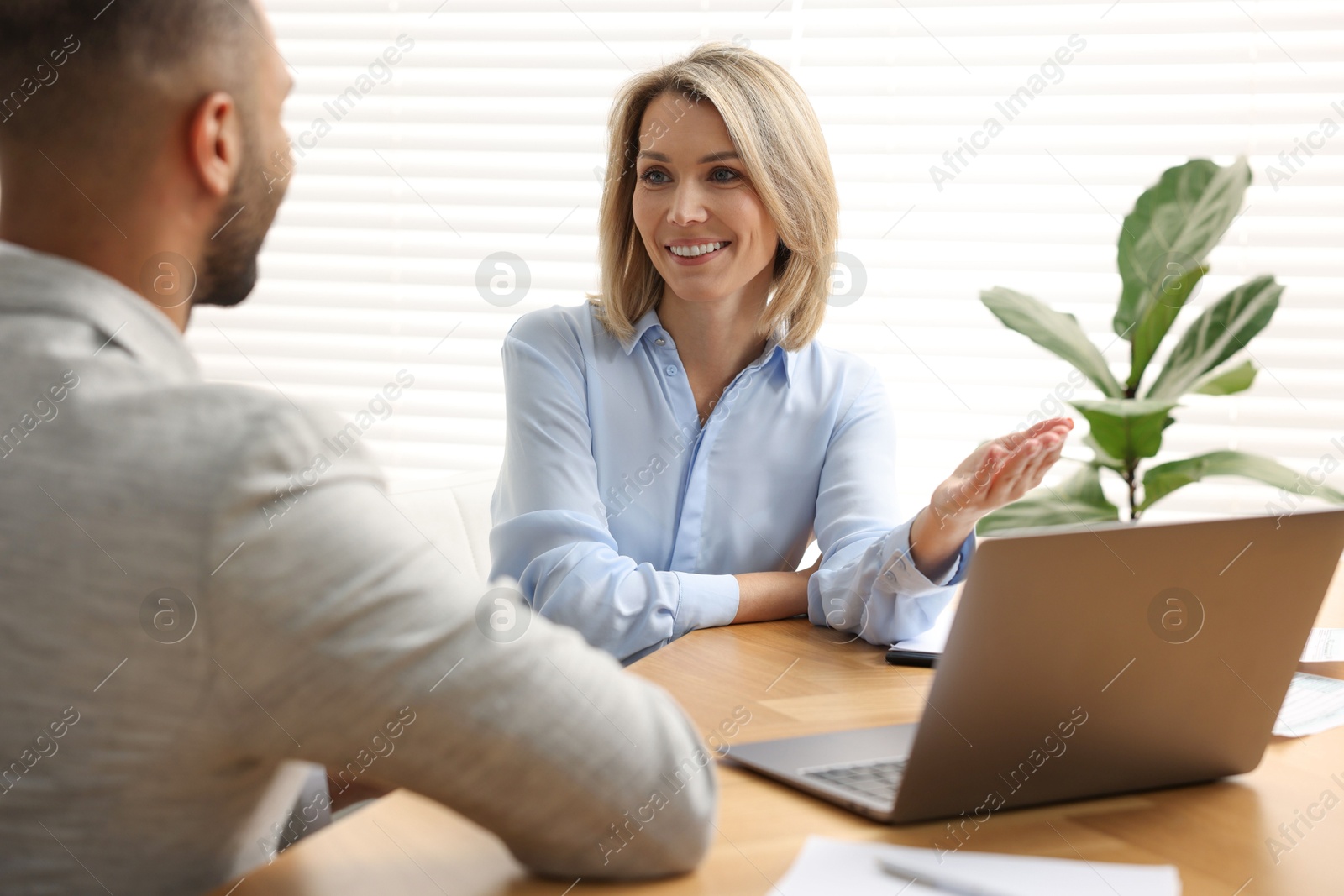 Photo of Coworkers working together at table in office