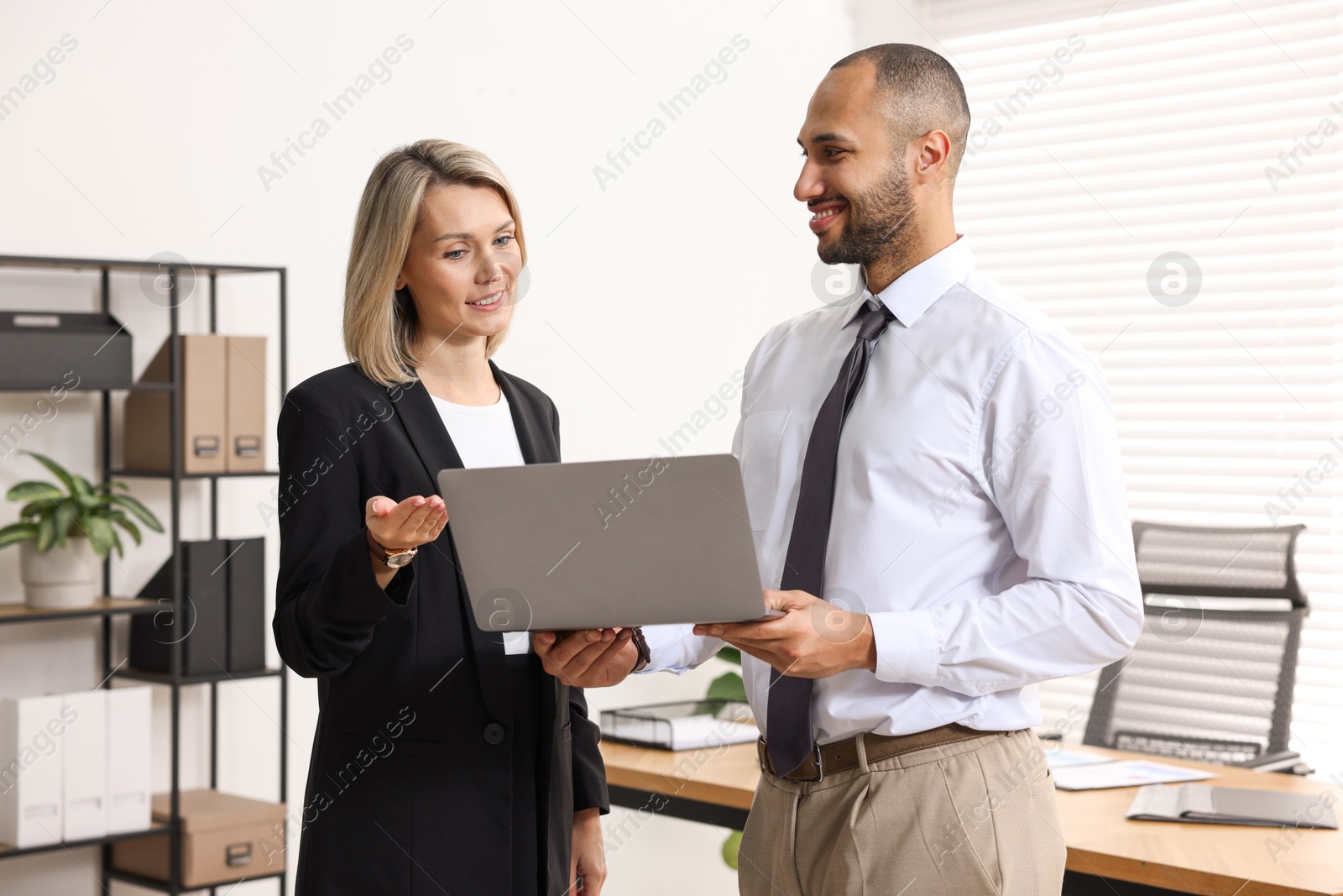 Photo of Coworkers with laptop working together in office