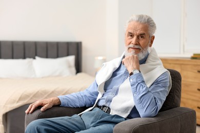 Photo of Handsome bearded man in armchair at home