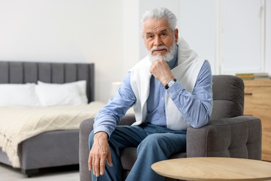 Photo of Handsome bearded man in armchair at home