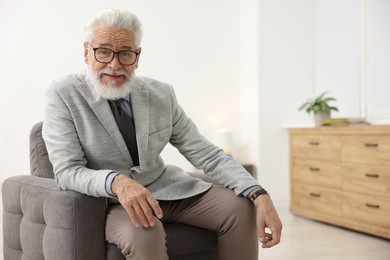 Photo of Portrait of handsome bearded man in armchair indoors, space for text