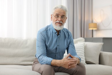 Photo of Portrait of handsome bearded man on sofa indoors