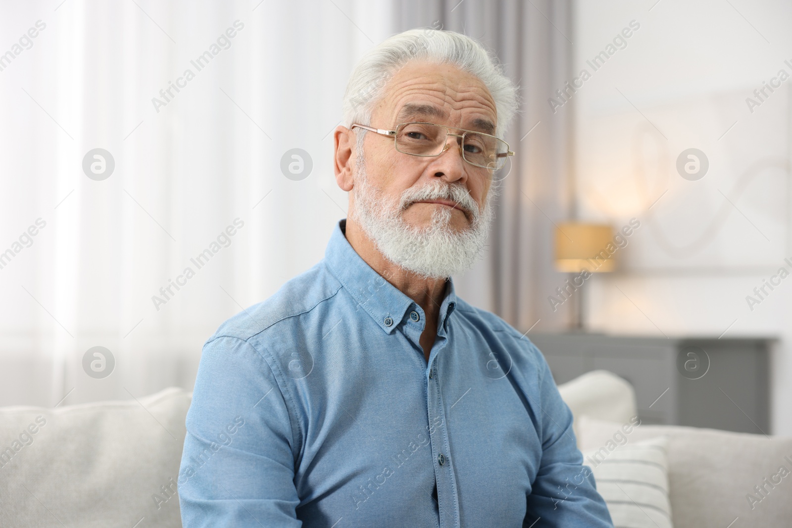 Photo of Portrait of handsome bearded man on sofa indoors