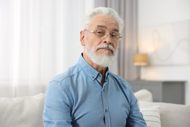 Photo of Portrait of handsome bearded man on sofa indoors