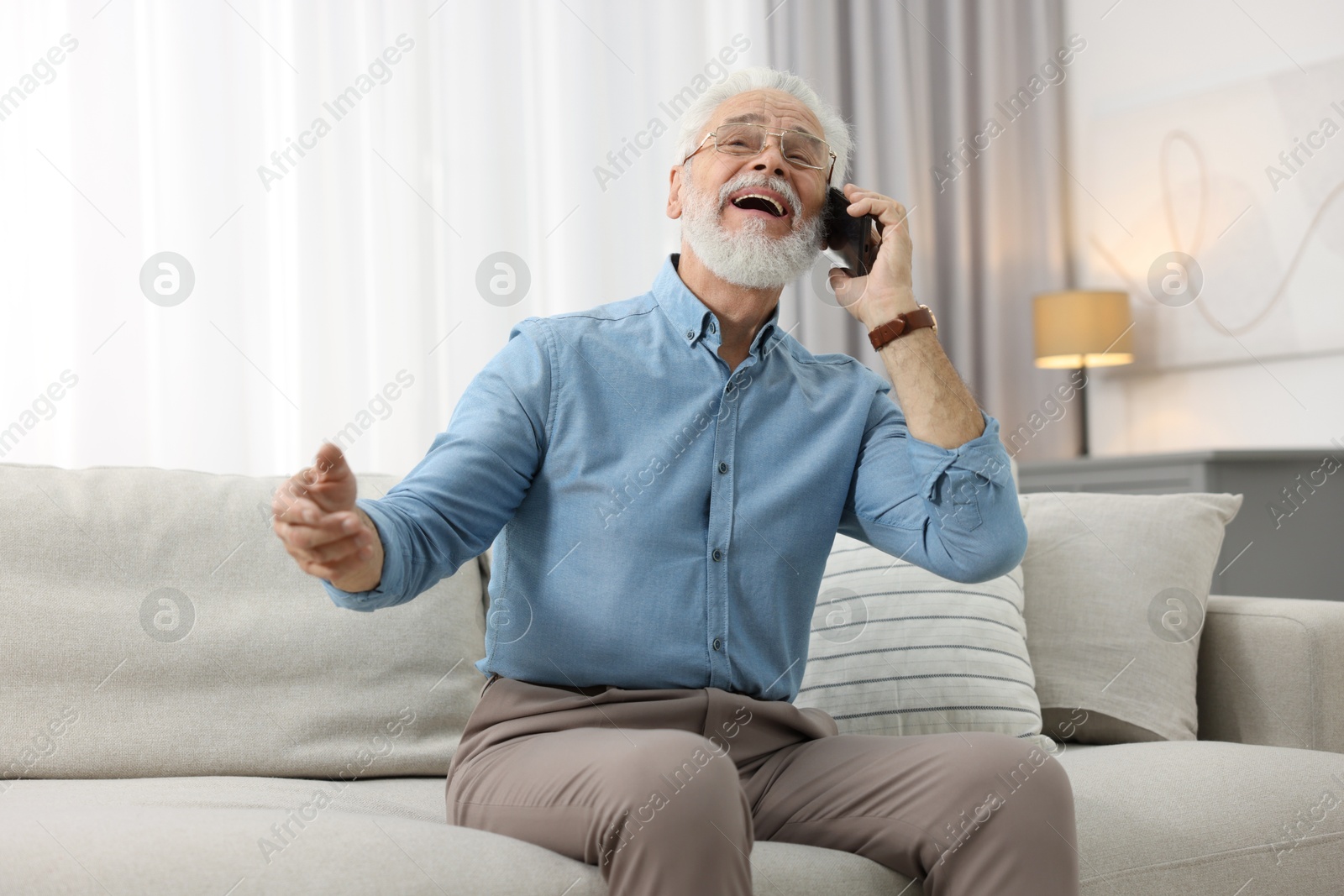 Photo of Handsome bearded man talking on smartphone indoors