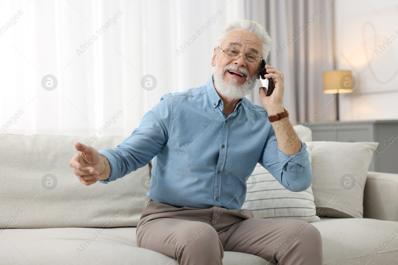 Photo of Handsome bearded man talking on smartphone indoors