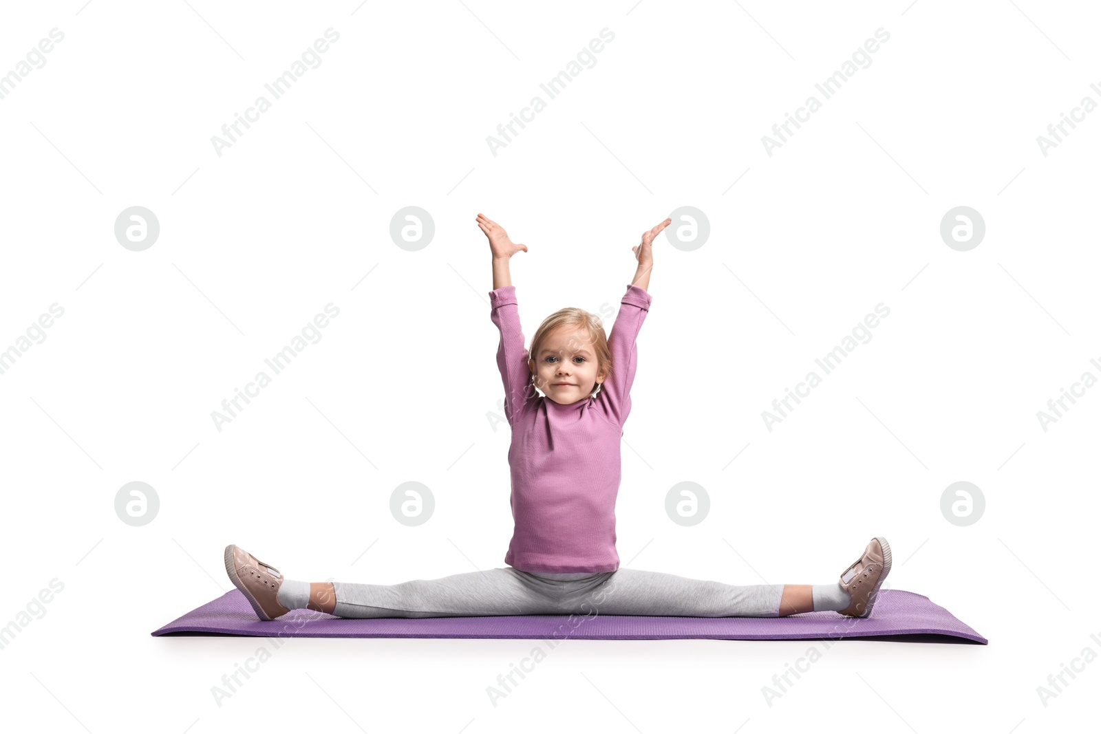 Photo of Little girl exercising on fitness mat against white background. Sport activity