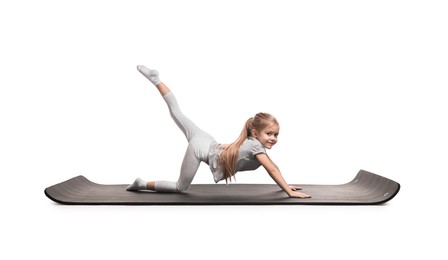 Photo of Little girl exercising on fitness mat against white background. Sport activity