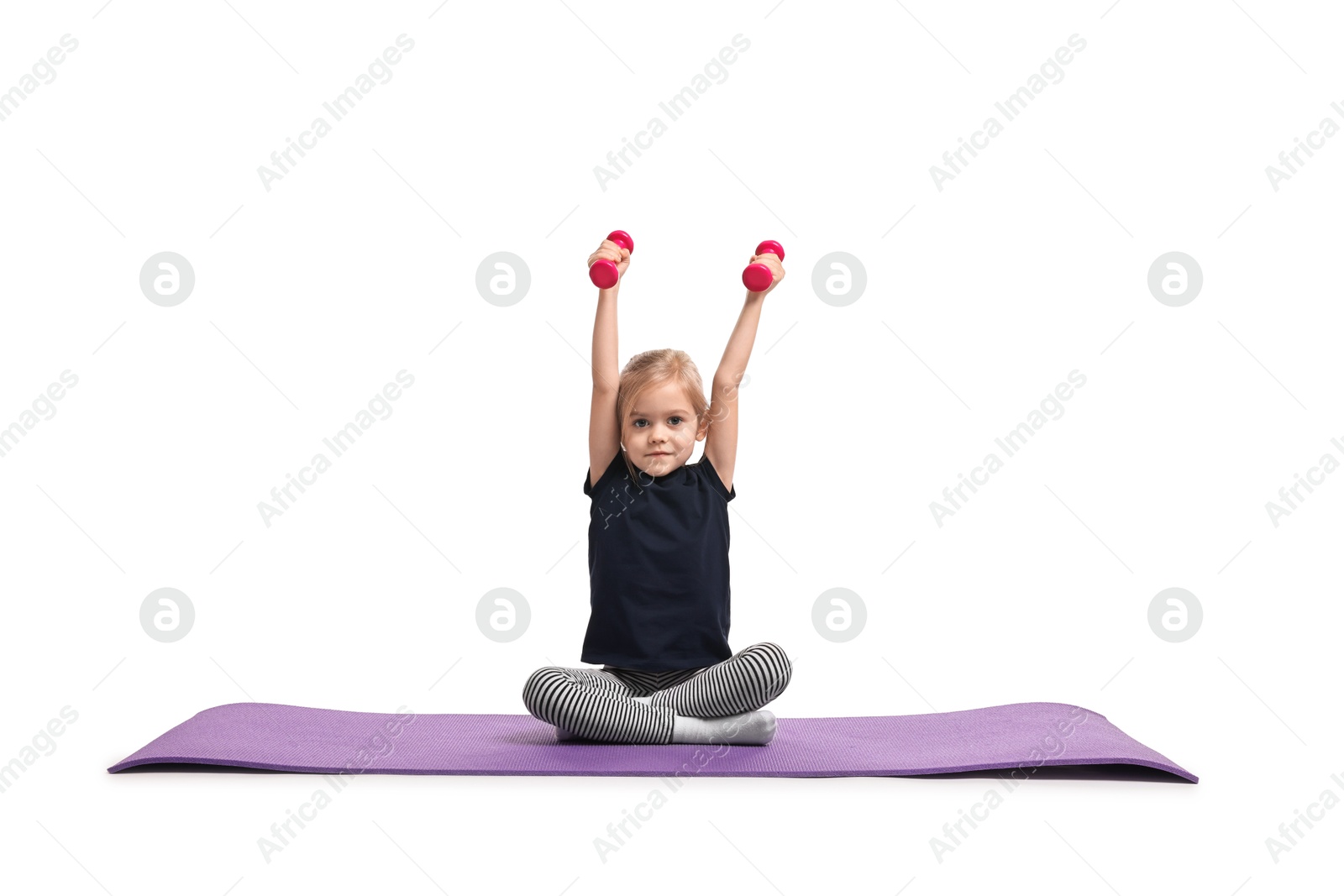 Photo of Little girl exercising with dumbbells on fitness mat against white background. Sport activity