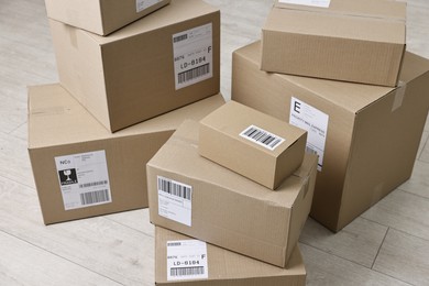 Cardboard parcel boxes with shipping labels on floor indoors