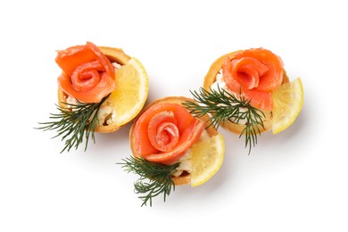 Photo of Tasty tartlets with salmon, lemon and dill isolated on white, top view