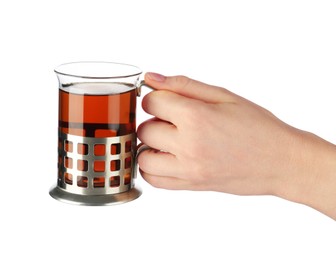 Woman holding glass of aromatic tea in holder on white background, closeup