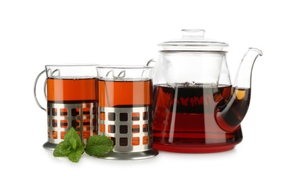 Photo of Glasses of aromatic tea in holders, teapot and mint isolated on white