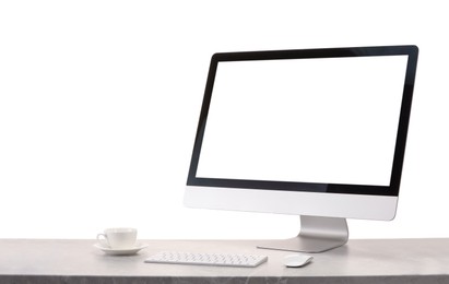 Photo of Computer monitor, keyboard, mouse and cup of drink on grey desk against white background