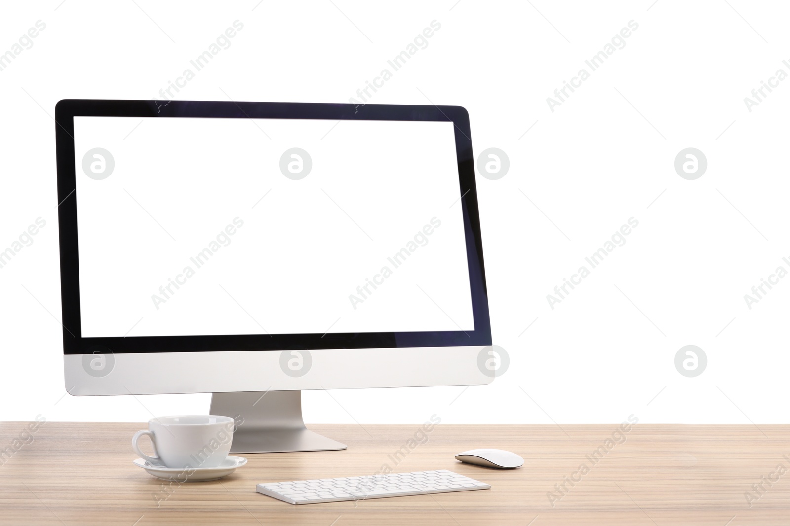 Photo of Computer monitor, keyboard, mouse and cup of drink on wooden desk against white background