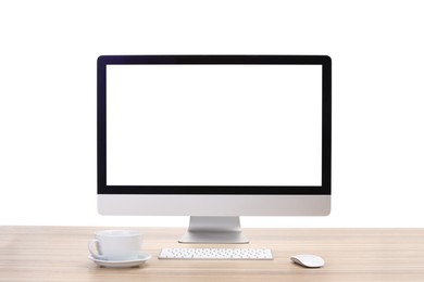 Photo of Computer monitor, keyboard, mouse and cup of drink on wooden desk against white background