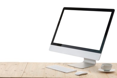 Photo of Computer monitor, keyboard, mouse and cup of drink on wooden desk against white background