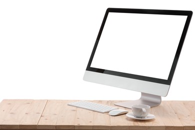 Photo of Computer monitor, keyboard, mouse and cup of drink on wooden desk against white background