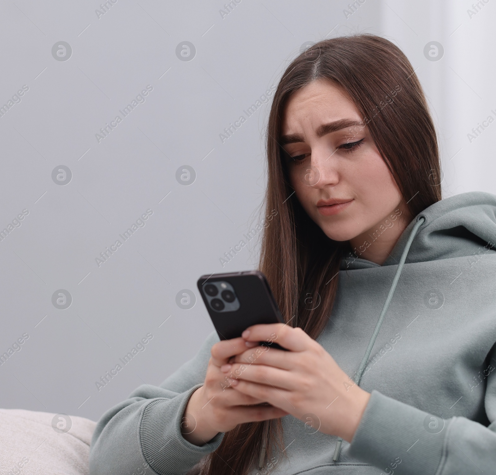 Photo of Stressed woman calling hotline for mental health help at home