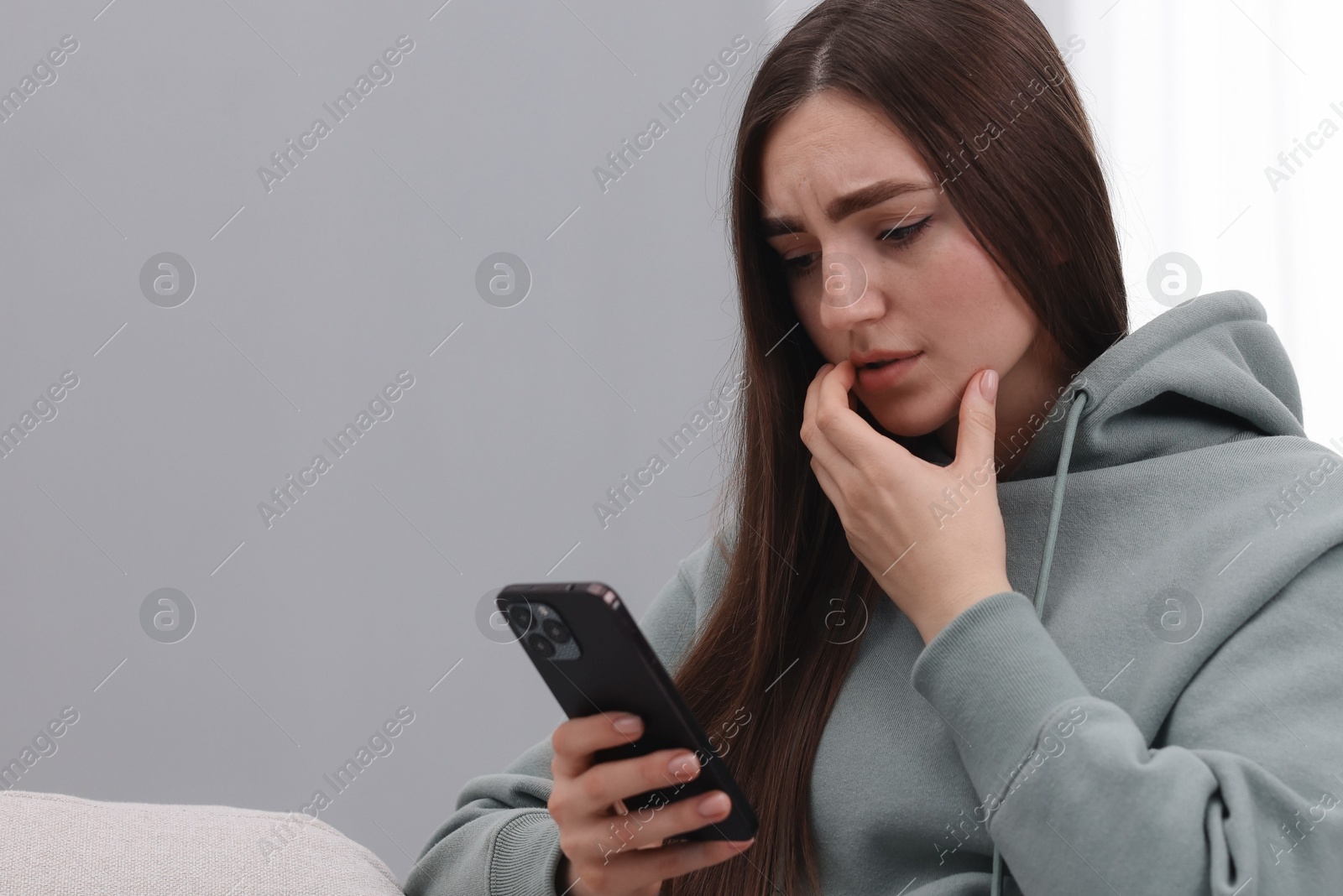 Photo of Stressed woman calling hotline for mental health help at home. Space for text