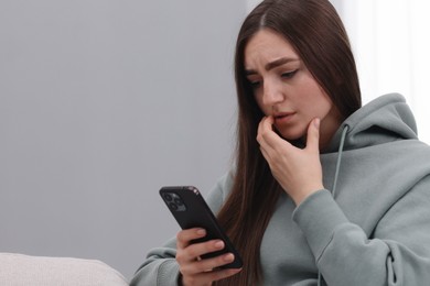 Photo of Stressed woman calling hotline for mental health help at home. Space for text